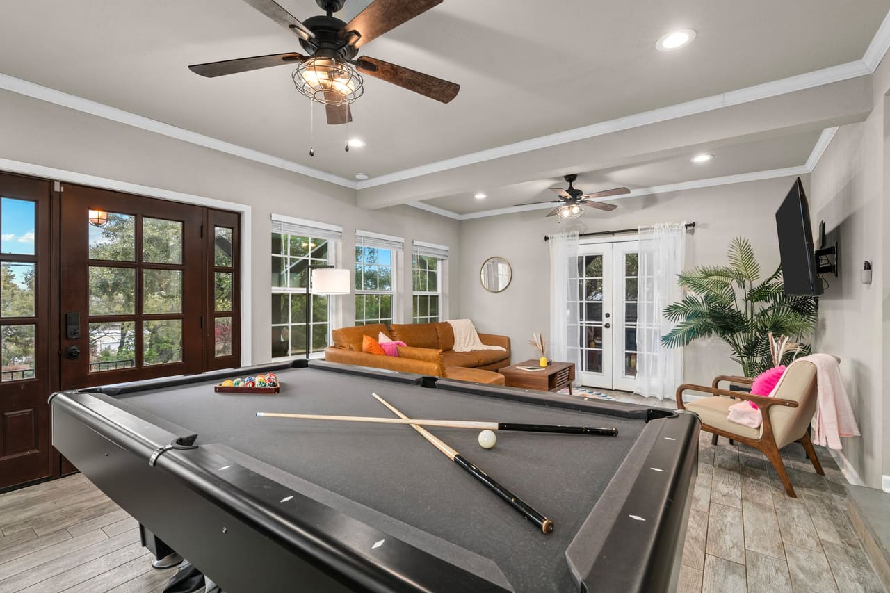 Cosmic Cowboy Retreat game room with pool table, leather sofa, and french doors