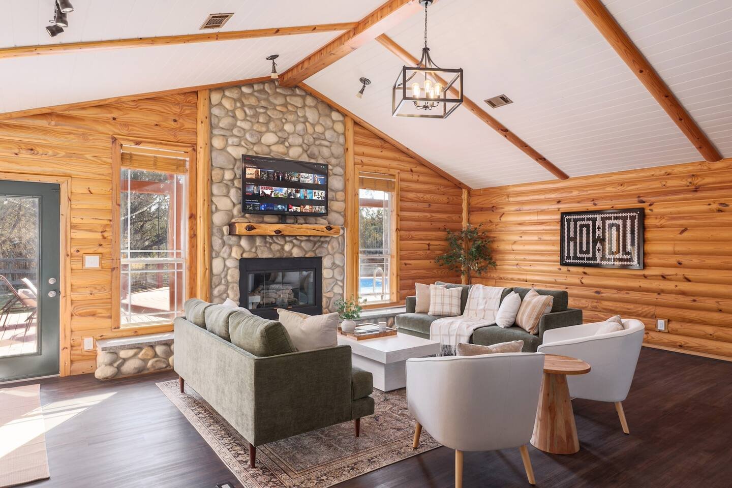 Fitzhugh Lodge · Log cabin living room with floor-to-ceiling stone fireplace