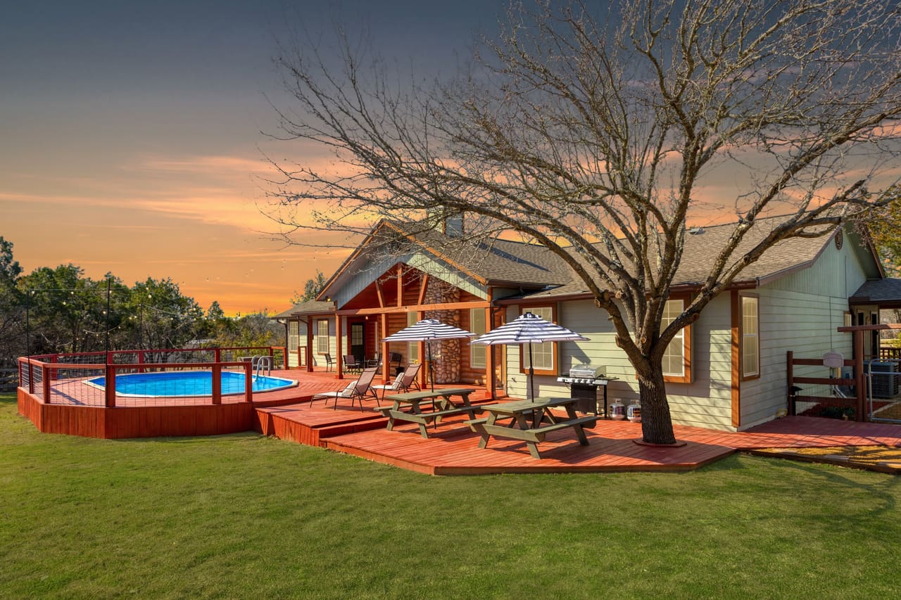 Fitzhugh Lodge cabin back deck at sunset with above-ground pool and picnic tables
